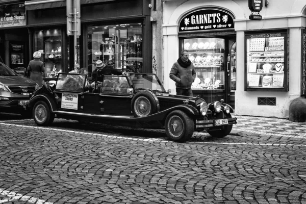 Tour of the city on an old car. Black and white. Stylized film.