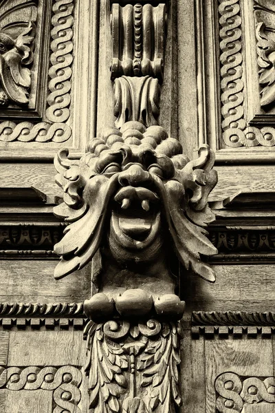 Woodcarving. Decoration vintage gate of the Old Town Hall. Sepia. Prague.