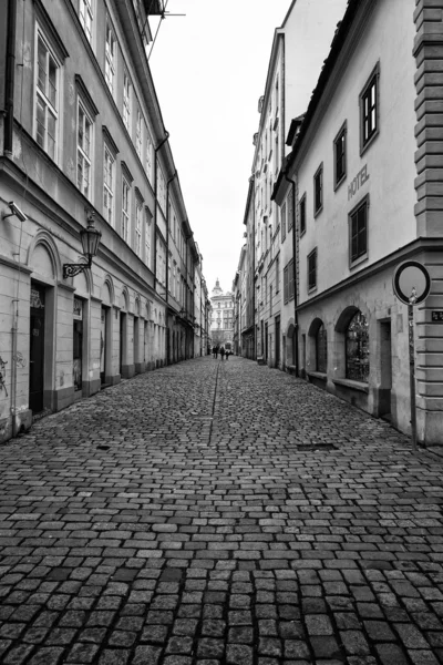 The narrow streets in the historic center of the Old Town of the Prague. Black and white. Stylized film. Large grains