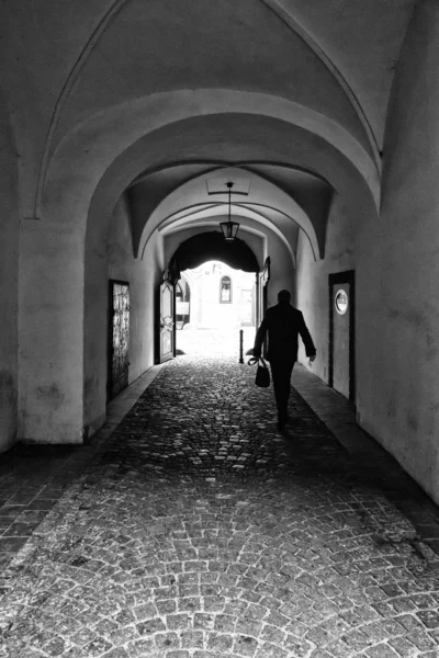 The narrow streets in the historic center of the Old Town of the Prague. Black and white. Stylized film. Large grains.