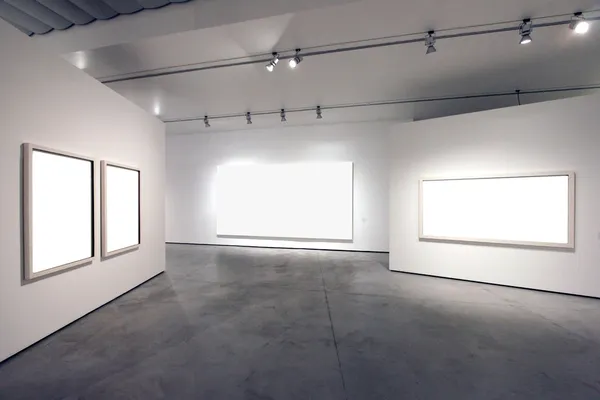 Empty frames in a gallery room against a white wall