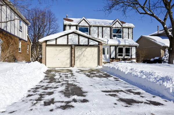 House and Driveway Covered with Fresh Snow