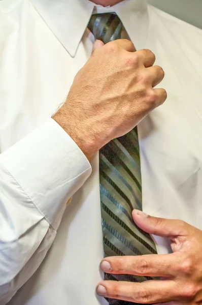 Man fixing a tie with hands