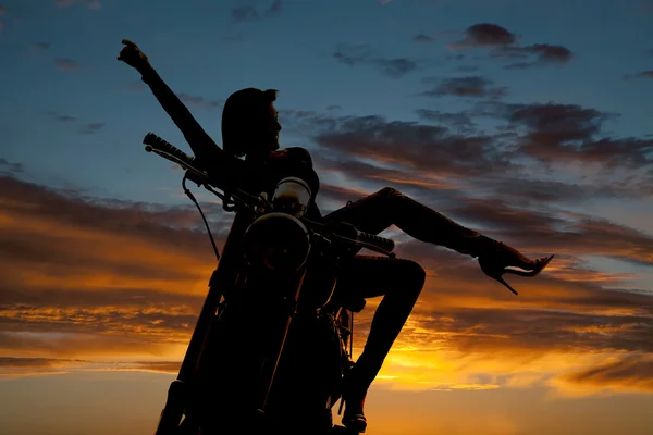 Silhouette woman on motorcycle arm leg out