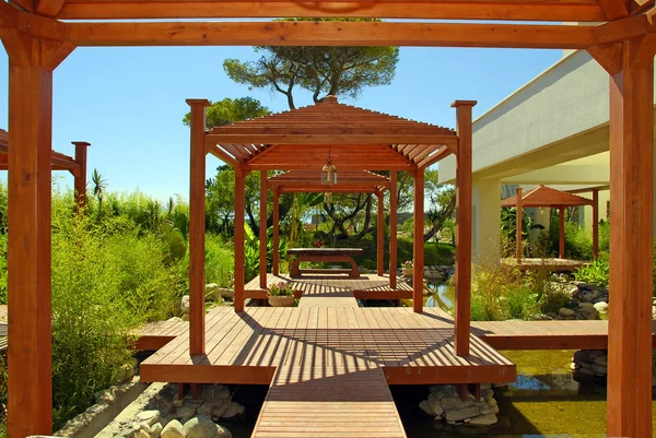 Wood pavilion, deck and tropical plants in summer resort