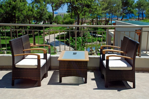 Rattan armchairs on terrace lounge in a luxury resort .