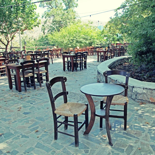 Tables and chairs of rural outdoor cafe, Greece