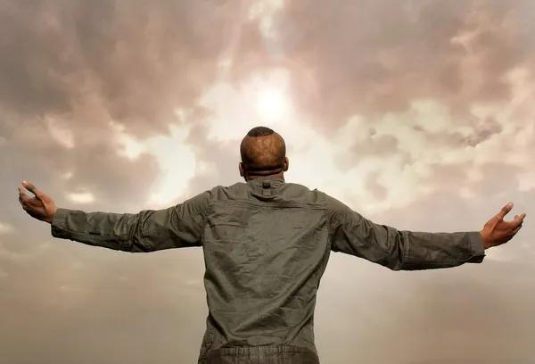 Man with outstretched arms looking at the sky