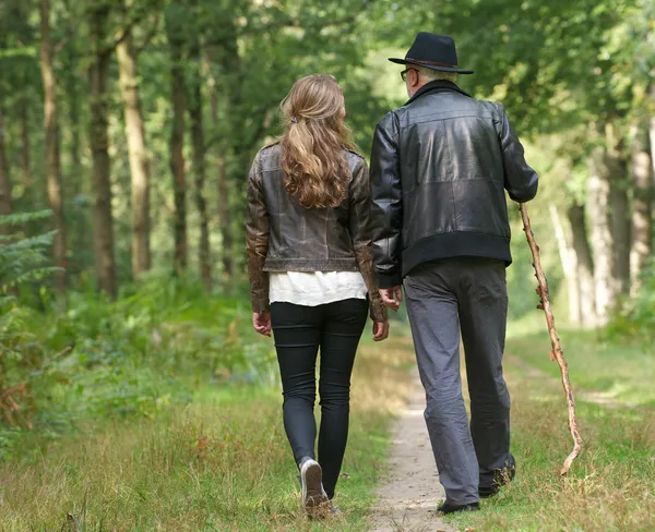 Father and daughter walking on path in the woods
