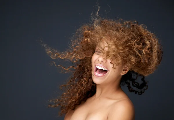 Portrait of a happy young woman laughing with hair blowing