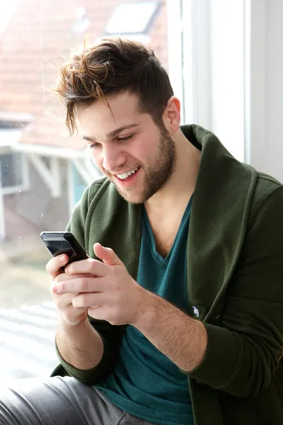 Man smiling and looking at mobile phone