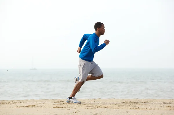 Young male jogger exercising at the beach