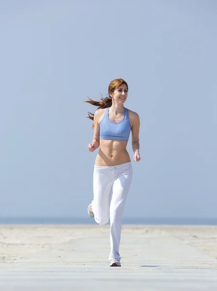 Smiling middle aged woman jogging