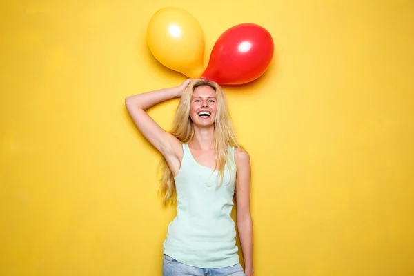 Funny young woman laughing with balloons