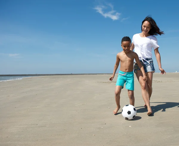 Mother playing with ball together with son