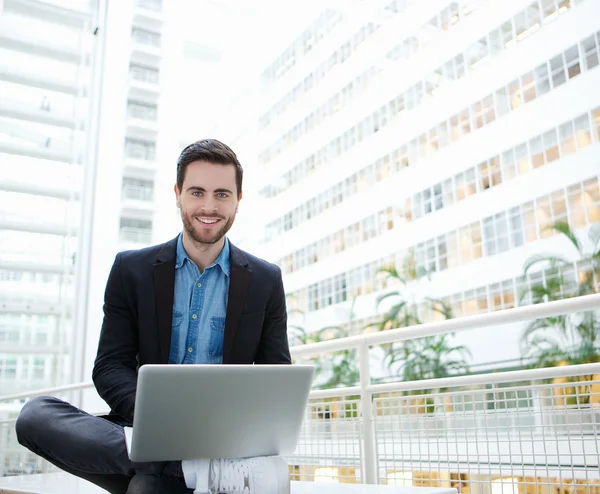 Friendly young man using laptop