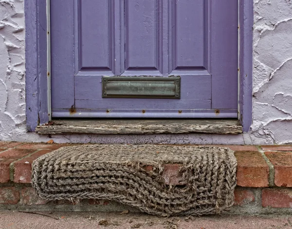 Purple Door with Worn Rug