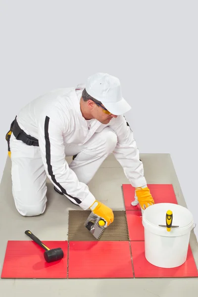 Worker Applies Tile Adhesive with Notched Trowel Tile on a Floor