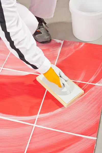 Worker clean with sponge trowel tile joints grout