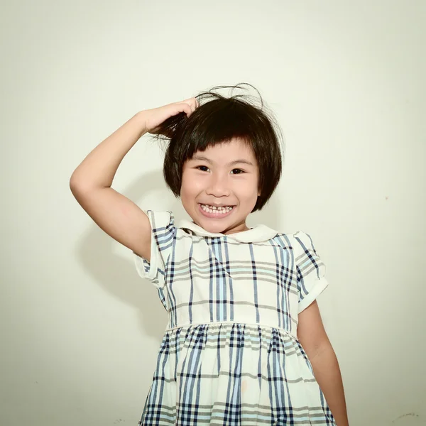 Happy Asian girl scratching her head and smiling