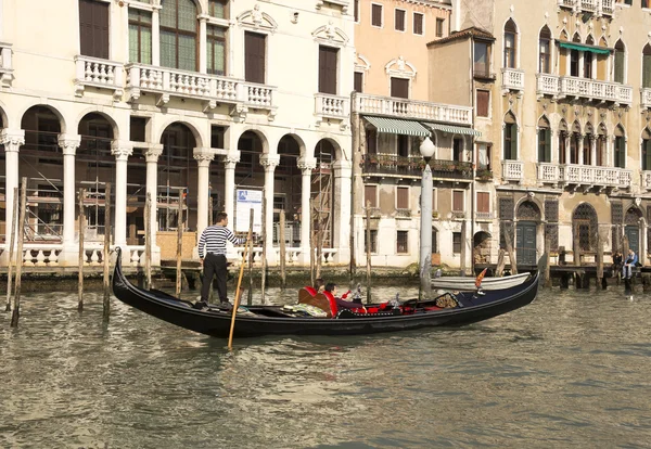 The gondolier floats on a gondola with tourists