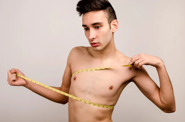 Young man measuring himself.