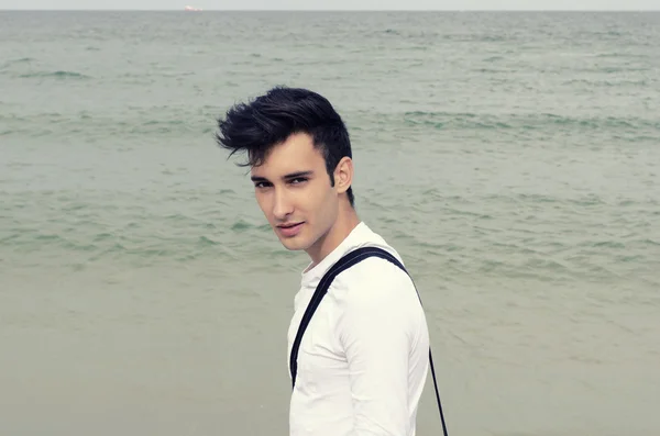 Young man enjoying his time on the beach on a sunny day, a lonely man