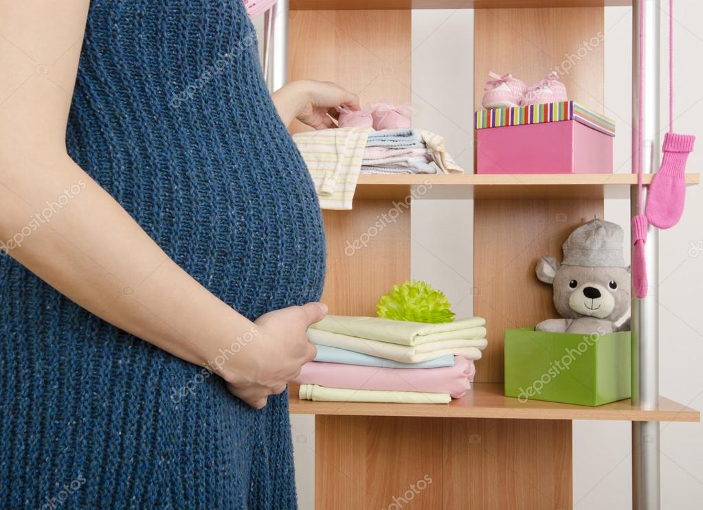 Mulher grávida comprar roupas para o beb u00ea recém nascido vestindo o armário com roupas dispos Artesanato Lucrativo ~ Mulher grávida comprar roupas para o beb u00ea recém nascido vestindo o armário com roupas dispos