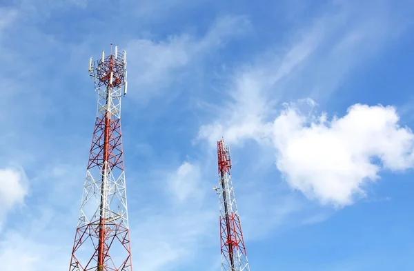 Cell phone and communication towers against blue sky with scatte