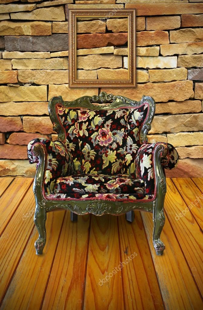 Antique armchair in the brick wall room with a frame hanging on ...