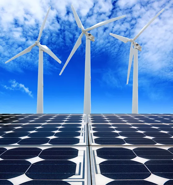 Solar panels and Wind Turbines under cloudy blue sky