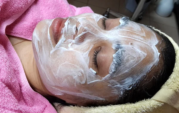 Asian woman with facial mask at a beauty salon