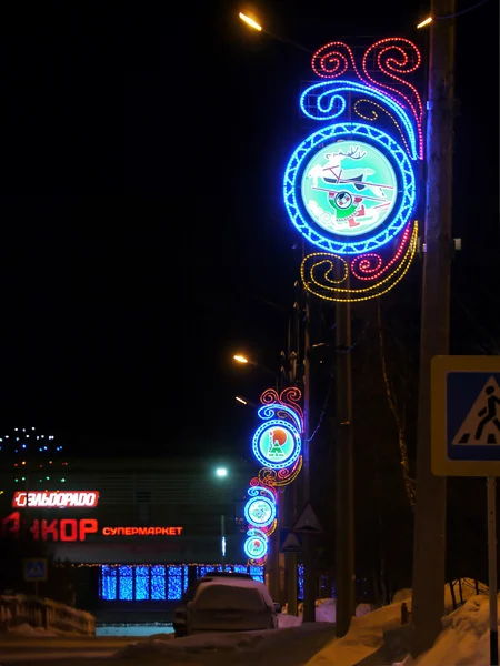 New Year - a holiday in Nadym, Russia - February 28, 2013. Festive street decorations. Beautifully illuminated building and trees. Far north, Nadym.