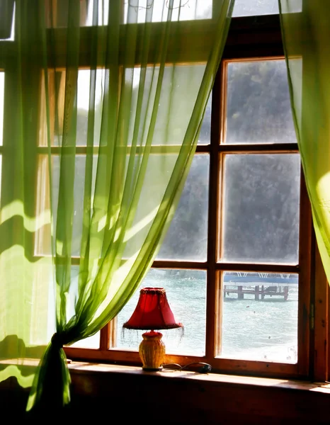 Wooden window with sea view in old hotel