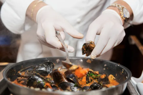 Chef frying mussels