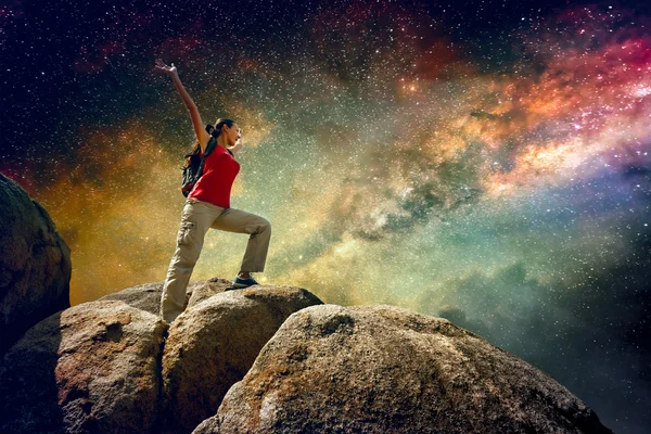 Hiker standing on top of a mountain and enjoying night sky view