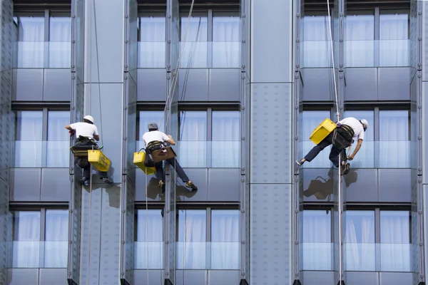 Three climbers wash windows