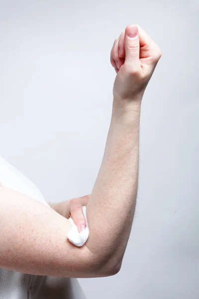 Appying a swab to an arm after blood sample