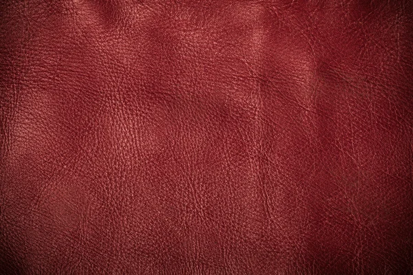 Red textured leather grunge background closeup
