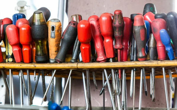 Assortment of tools hanging on wall. Screwdrivers in mechanic garage car service