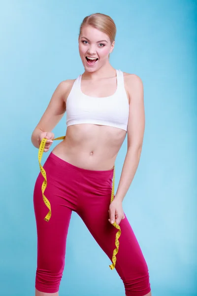 Diet. Fitness woman fit girl with measure tape measuring her waist