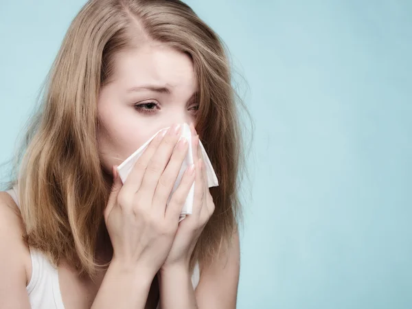 Sick girl sneezing in tissue. Health
