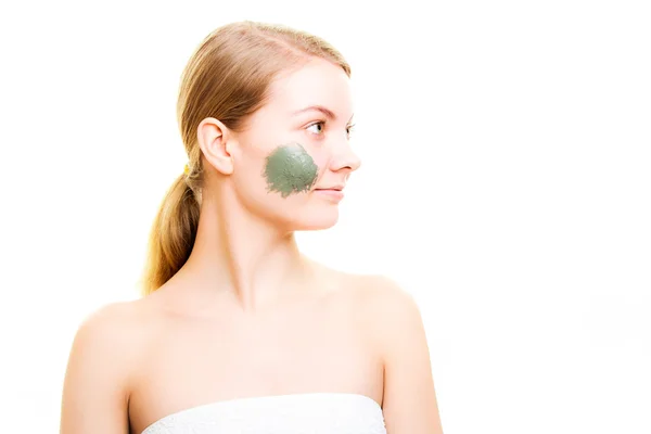 Woman with clay mud mask on face.