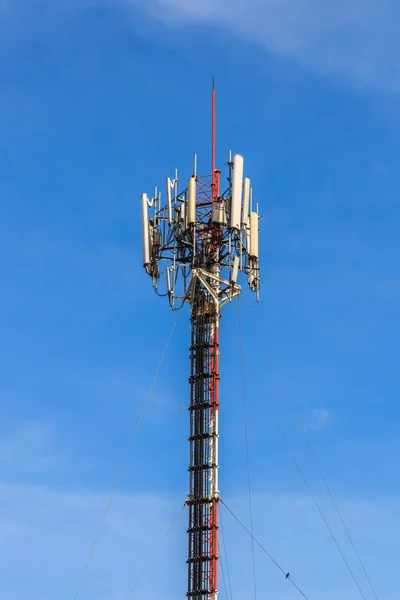 Telecommunication Tower with Antennas against Blue sky Background