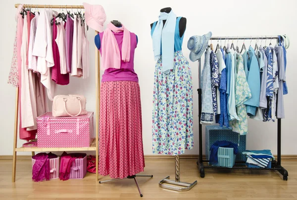 Dressing closet with pink and blue clothes arranged on hangers with outfit on two mannequins.
