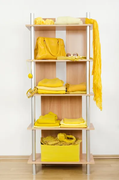 Yellow clothes nicely arranged on a shelf.