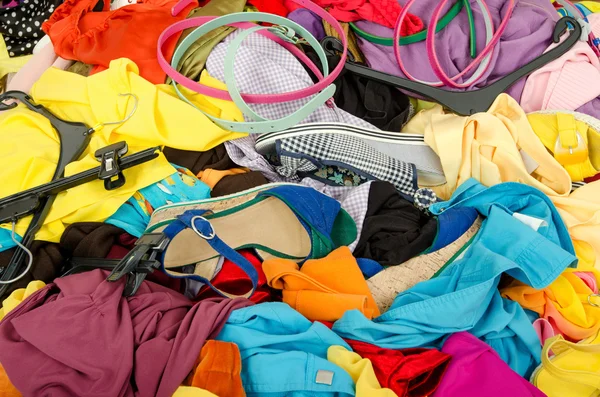 Close up on a big pile of clothes and accessories thrown on the ground.