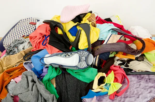 Close up on a big pile of clothes and accessories thrown on the ground.