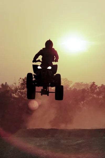 Silhouette ATV jump on dirt track