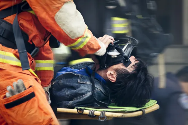The rescue workers move hurt person with a stretcher